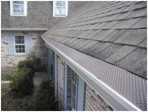 Gutter guards installed over the gutters along a home's gray roof.